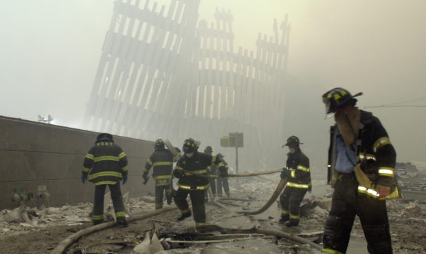 FILE - In this Sept. 11, 2001, file photo, firefighters work beneath the destroyed mullions, the ve...