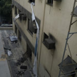 A rope made of bed sheets used to escape from the upper floor of the Badim Hospital hangs from a window, where a fire left at least 11 people dead, in Rio de Janeiro, Brazil, Friday, Sept. 13, 2019. The fire raced through the hospital forcing staff to wheel patients into the streets on beds or in wheelchairs. (AP Photo/Leo Correa)