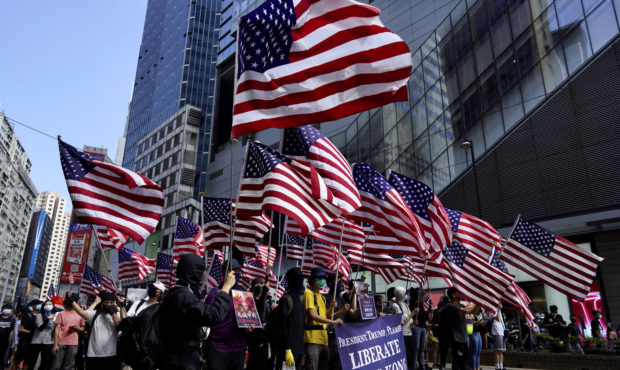 Protesters carry U.S. flags during a rally in Hong Kong, Sunday, Sept. 15, 2019. Thousands of Hong ...