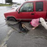 Felipe Morales works on getting his truck out of a ditch filled with high water during a rain storm stemming from rain bands spawned by Tropical Storm Imelda on Tuesday, Sept. 17, 2019, in Houston. He was able to get help when a man with a truck helped pull him from the ditch. (Brett Coomer/Houston Chronicle via AP)