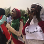 FILE - In this June 30, 2019 file photo, Sudanese protesters chant slogans as they march during a demonstration against the ruling military council, in Khartoum, Sudan. The sign in Arabic reads, "peace." Sudan’s uprising has ushered in a new era both for the nation and for Sudanese women after three decades of autocratic rule by Omar al-Bashir. Sudanese women played a pivotal role in the protests that brought down al-Bashir, and under a joint military-civilian council in power now, they hope for more freedom and equality, and seek to overturn many of the restrictive Islamic laws from the previous era. (AP Photo/Hussein Malla, File)