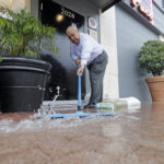 Paco Vargas pushes floodwaters from Tropical Depression Imelda away from his business Wednesday, Sept. 18, 2019, in Galveston, Texas. (AP Photo/David J. Phillip)