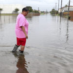 Cheryl Stephens takes advantage of a break in the rain from Tropical Depression Imelda, to check out the high water in her neighborhood at 69th Street and Heards Lane in Galveston, Texas, Wednesday, Sept. 18, 2019. (Jennifer Reynolds/The Galveston County Daily News via AP)