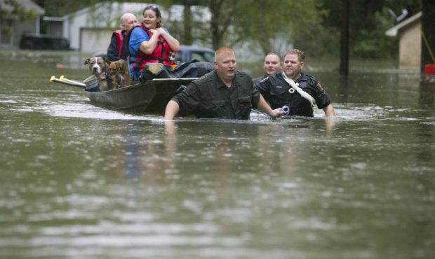 Splendora Police Lt. Troy Teller, left, Cpl. Jacob Rutherford and Mike Jones pull a boat carrying A...