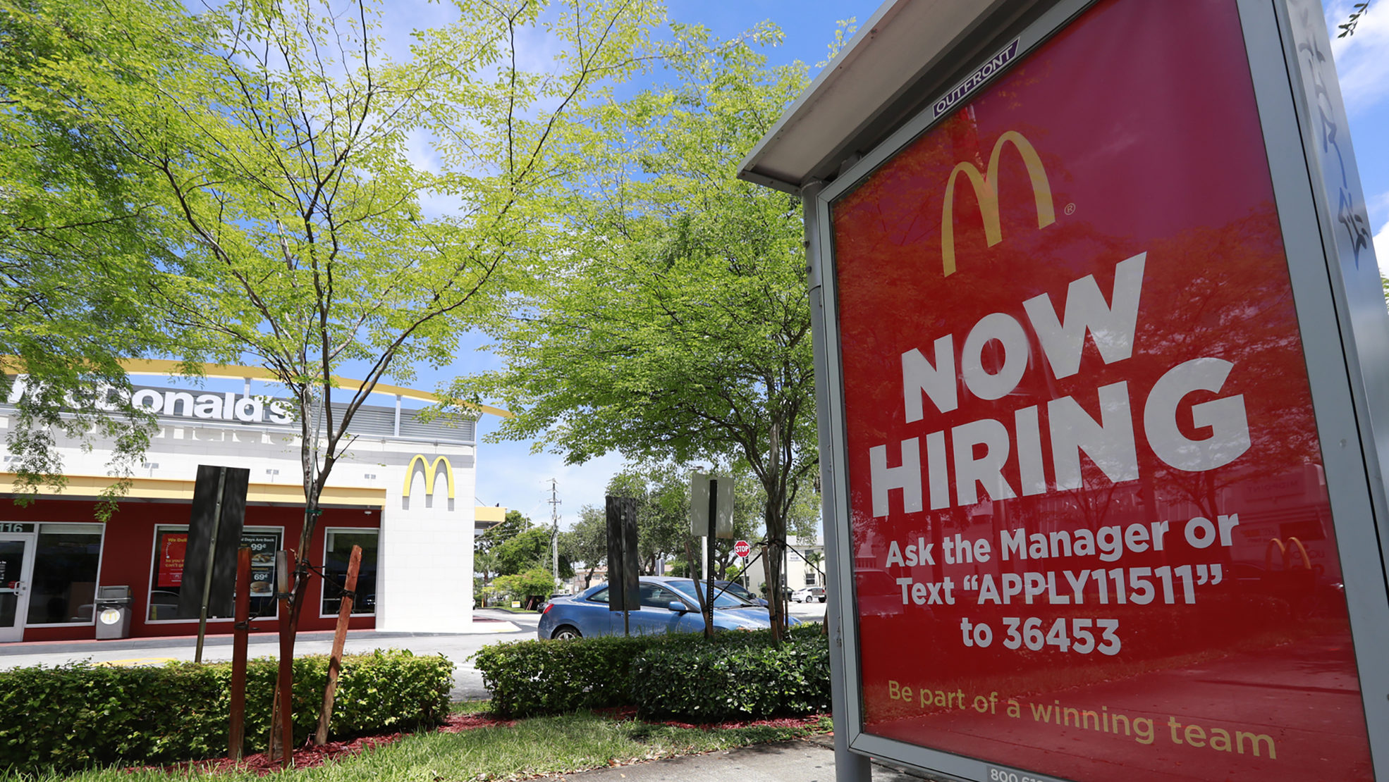 FILE - In this Monday, July 1, 2019, file photo, a "Now Hiring" sign appears on a bus stop in front...