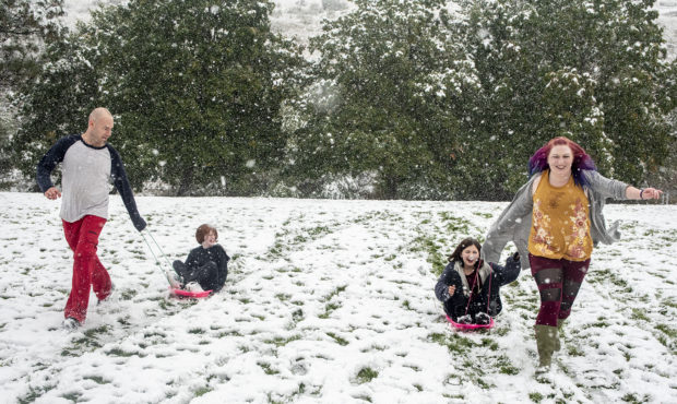 Tommy Little, from left, Cody Little, Kyndra Neal and Tanya Little use the snow accumulation to sle...