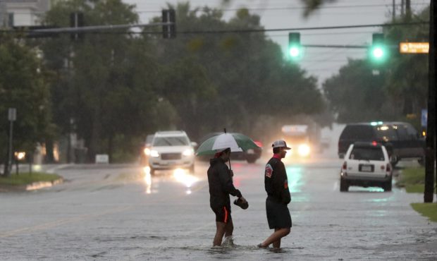 Two men wade across 19th Street in Galveston, Texas. (Photo credit: CNN)...