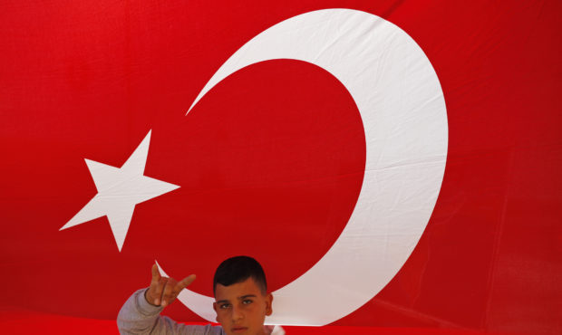 A youth flashes a hand gesture representing the Turkish far-right gray wolves organisation as he st...
