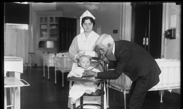 In this 1915-1923 photo made available by the Library of Congress, a doctor examines a child with a...