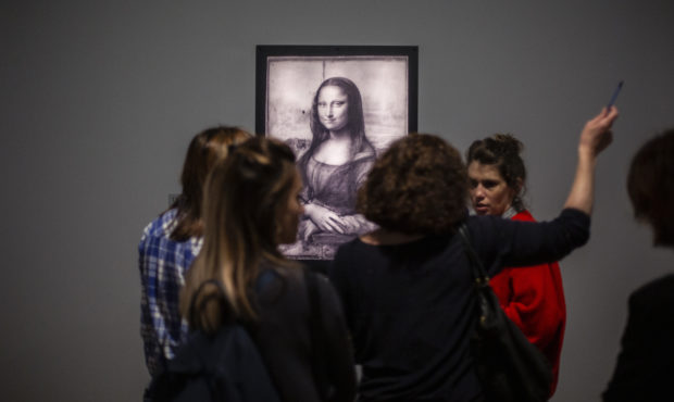 Journalists gather near a Mona Lisa image by Leonardo da Vinci during a visit at the Louvre museum ...