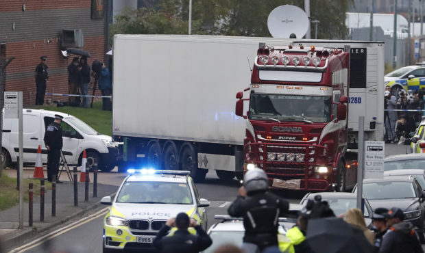 Police escort the truck, that was found to contain a large number of dead bodies, as they move it f...