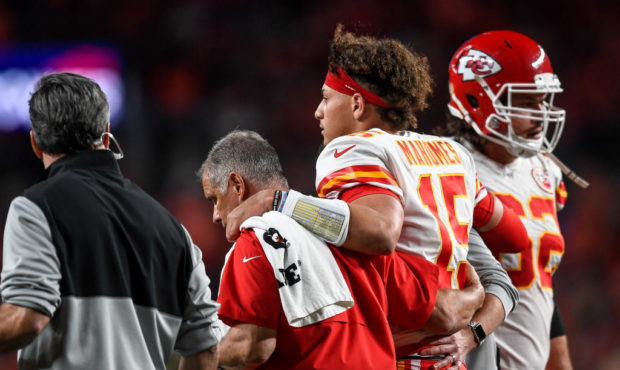 Patrick Mahomes No. 15 of the Kansas City Chiefs is helped off the field by trainers after sufferin...