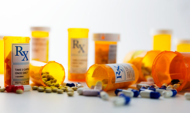 Prescription bottles and pills on a counter. Photo courtesy of Getty Images....