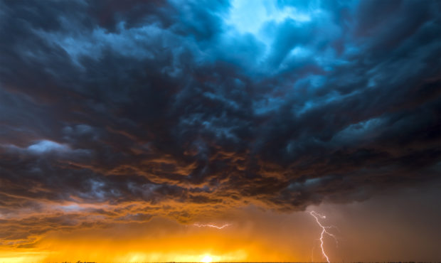 A nighttime, tornadic mezocyclone lightning storm shoots bolt of electricity to the ground and ligh...