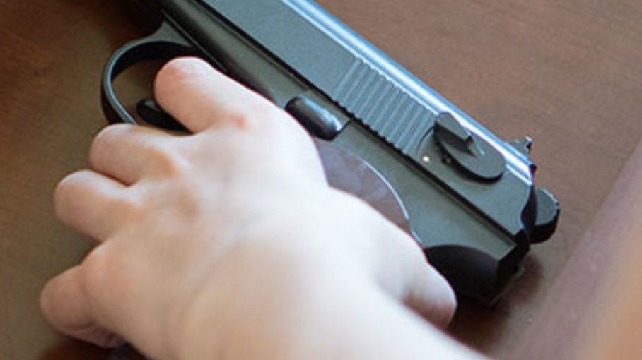 a person holds a gun, experts urge gun safety after increased gun deaths...