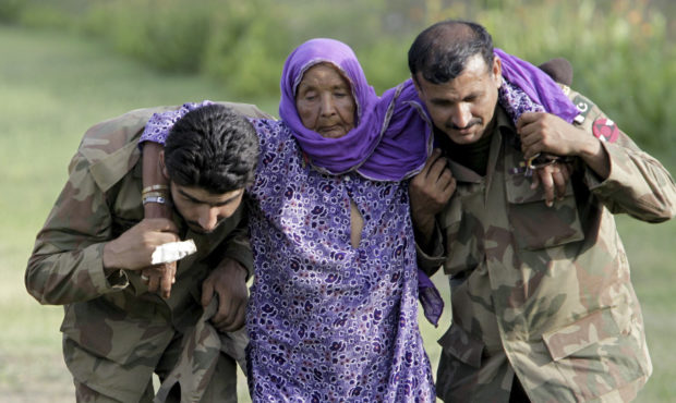 FILE - In this July 30, 2010, file photo, Pakistani army soldiers help an elderly villager evacuate...