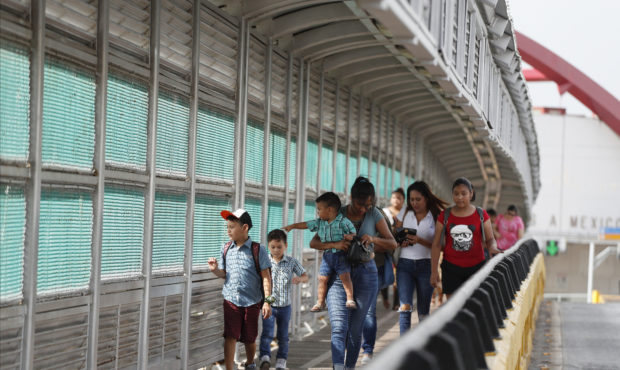 FILE - In this June 28, 2019 file photo, local residents with visas walk across the Puerta Mexico i...
