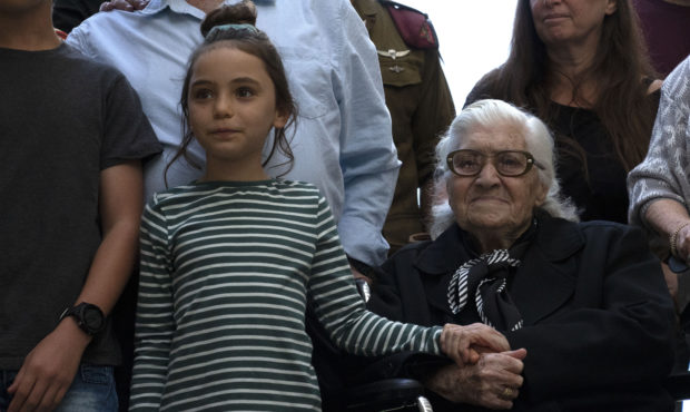 Melpomeni Dina holds the hand of an Israeli girl during a reunion at the Yad Vashem Holocaust memor...