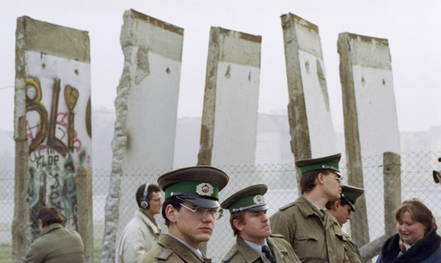 FILE - In this Nov. 13, 1989, file photo, East German border guards stand in front of segments of t...