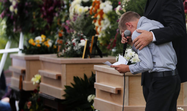 A boy pauses as he speaks next to the coffins of Dawna Ray Langford, 43, and her sons Trevor, 11, a...