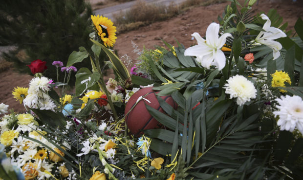 A basketball sits on a bed of flowers decorating the grave that contain the remains of 12-year-old ...