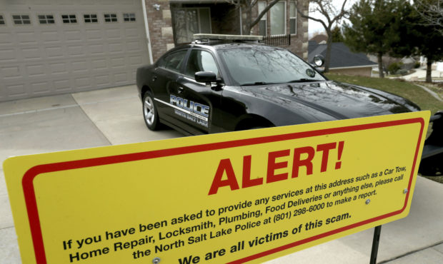 FILE - This March 21, 2019 file photo shows a warning sign and a police officer's vehicle at Walt G...