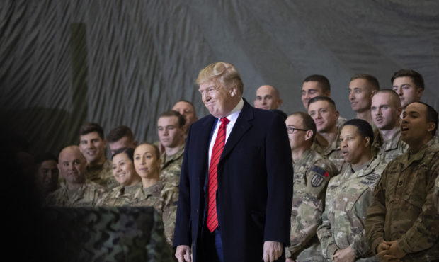 President Donald Trump smiles before addressing members of the military during a surprise Thanksgiv...