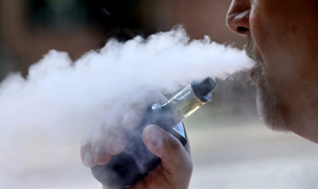 FILE -  file photo, a man exhales while smoking an e-cigarette. Health officials investigating a na...