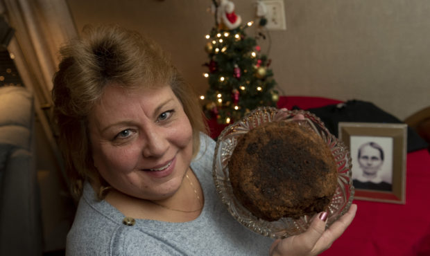 In this Dec. 9, 2019, photo Julie Ruttinger, of Tecumseh, Mich., holds a 141-year-old fruitcake, a ...