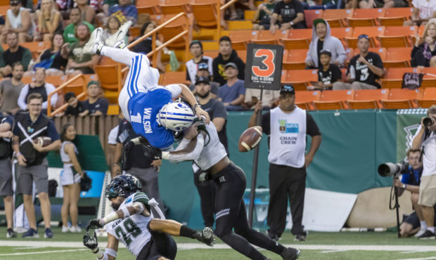 BYU quarterback Zach Wilson (1) loses the football on a hit by Hawaii defensive back Eugene Ford, r...