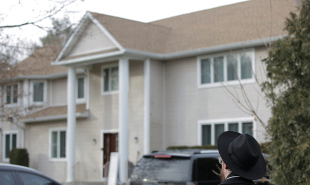 An onlooker stands outside a rabbi's residence in Monsey, N.Y., Sunday, Dec. 29, 2019, following a ...