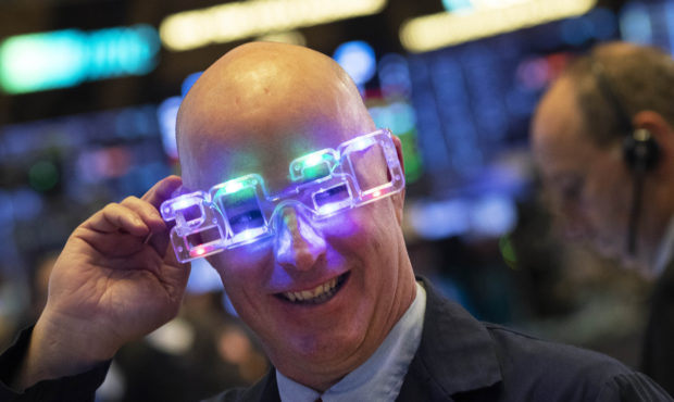Stock trader John O'Hara tries on his New Year's 2020 party glasses at New York Stock Exchange, Tue...