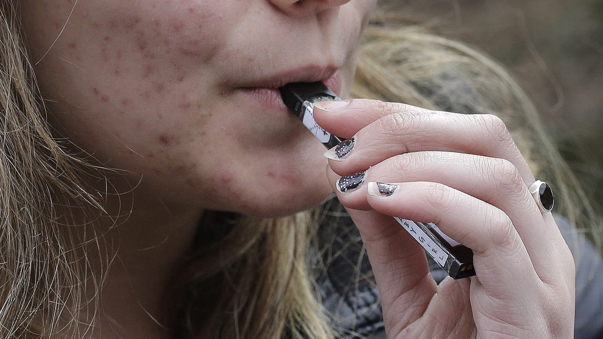 FILE - A high school student uses a vaping device. (AP Photo/Steven Senne, File)...