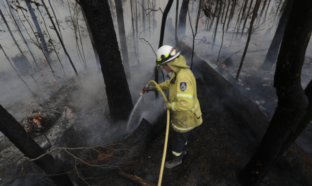 A firefighter manages a controlled burn near Tomerong, Australia, Wednesday, Jan. 8, 2020, in an ef...