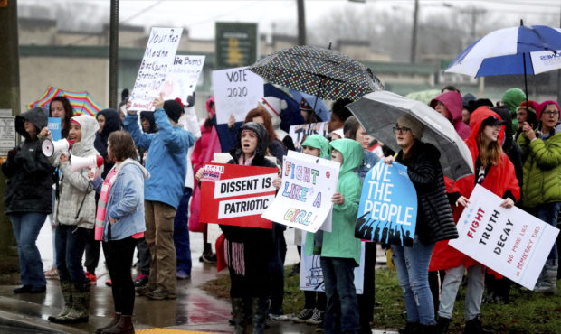 People endure drizzling rain as they participate in the Women's March, organized by Power Together ...