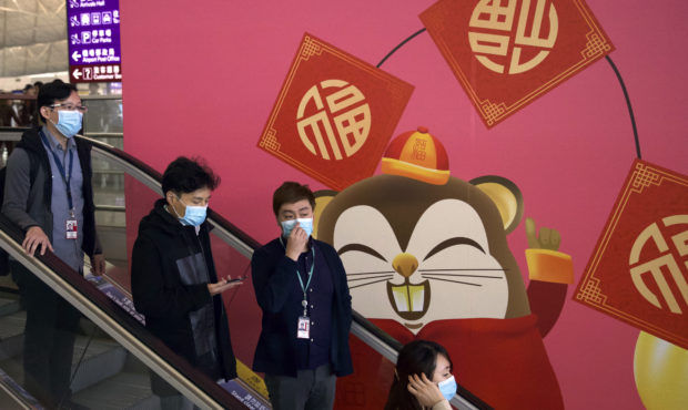 People wear face masks as they ride an escalator at the Hong Kong International Airport in Hong Kon...