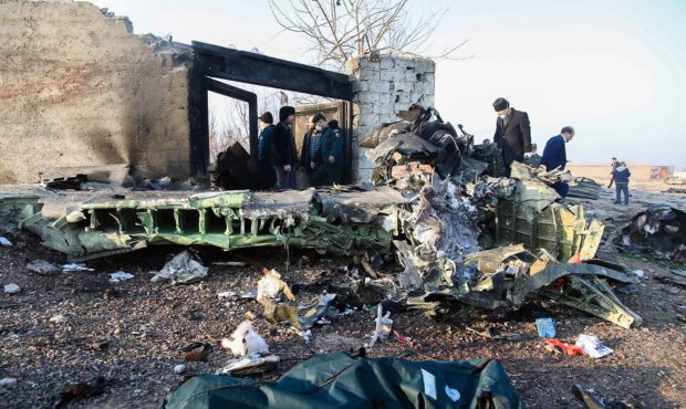 TOPSHOT - People stand near the wreckage after a Ukrainian plane carrying 176 passengers crashed ne...