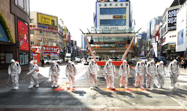 South Korean army soldiers wearing protective suits spray disinfectant to prevent the spread of the...