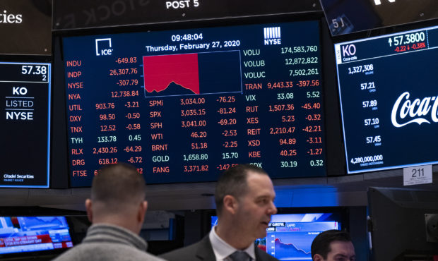 Stocks reflect declines on monitors as people work on the floor of the New York Stock Exchange Thur...