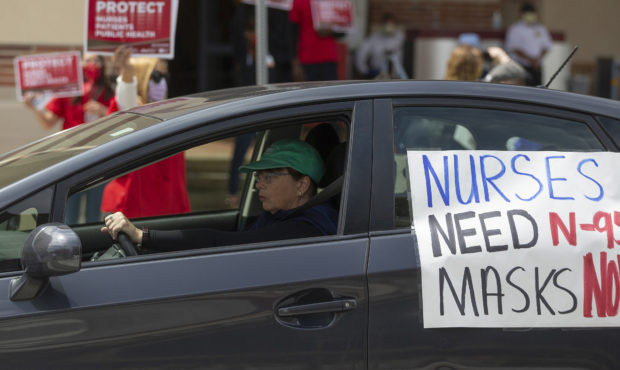 FILE - In this April 13, 2020, file photo, a car passes nurses protesting the lack of N95 respirato...