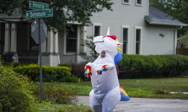 Corey Jurgensen runs along East Henry Avenue wearing an inflatable unicorn costume. Jurgensen has b...