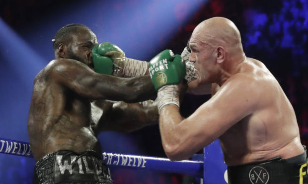 FILE - In this Feb. 22, 2020, file photo, Tyson Fury, of England, lands a right to Deontay Wilder, ...