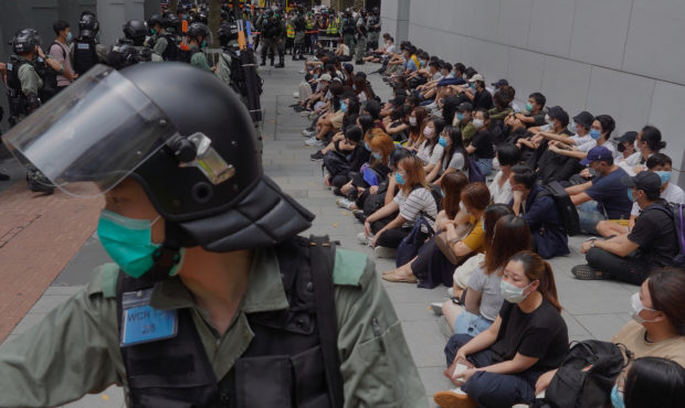 Riot police guard detained anti-government protesters in the Causeway Bay district of Hong Kong, We...
