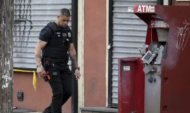 A member of the Philadelphia bomb squad surveys the scene after an ATM machine was blown-up at 2207...