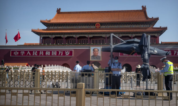 Chinese police officers stand guard in front of Tiananmen Gate near Tiananmen Square in Beijing, Th...