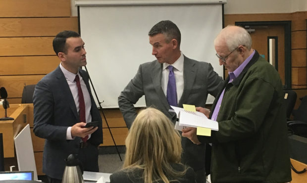 Charles Cox reviews legal papers with his attorneys, Ted Buck (center), Evan Bariault (left) and An...