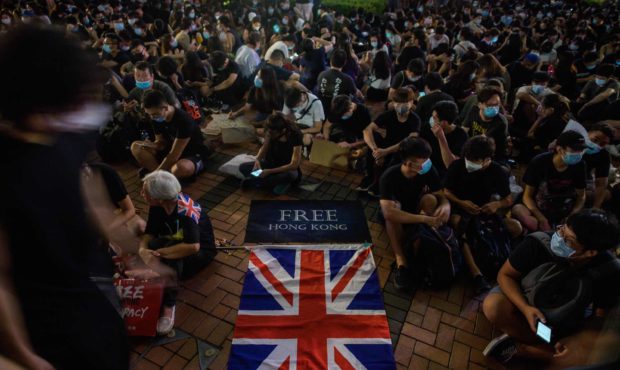 A British Union Jack flag is displayed as protesters gather along a fenced-off Victoria Harbour pie...