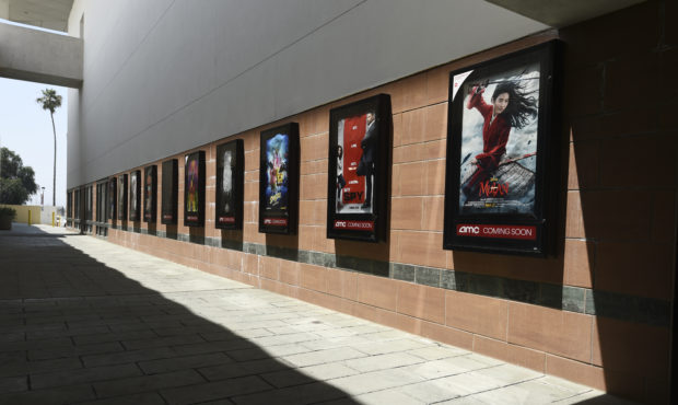 FILE - Posters for upcoming movies are displayed in an empty corridor at the currently closed AMC B...