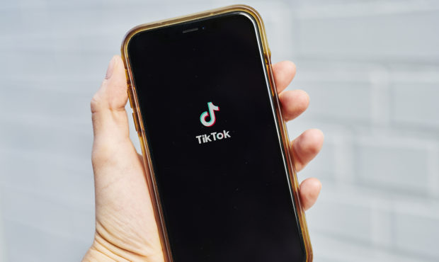 Signage for ByteDance Ltd.'s TikTok app is displayed on a smartphone in an arranged photograph tak...