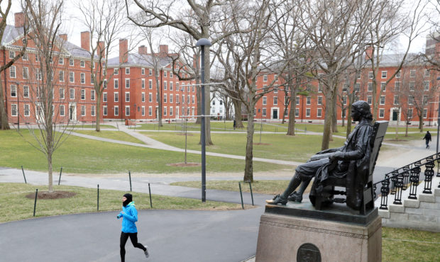 CAMBRIDGE, MASSACHUSETTS  - MARCH 23:  A runner crosses Harvard Yard on March 23, 2020 in Cambridge...